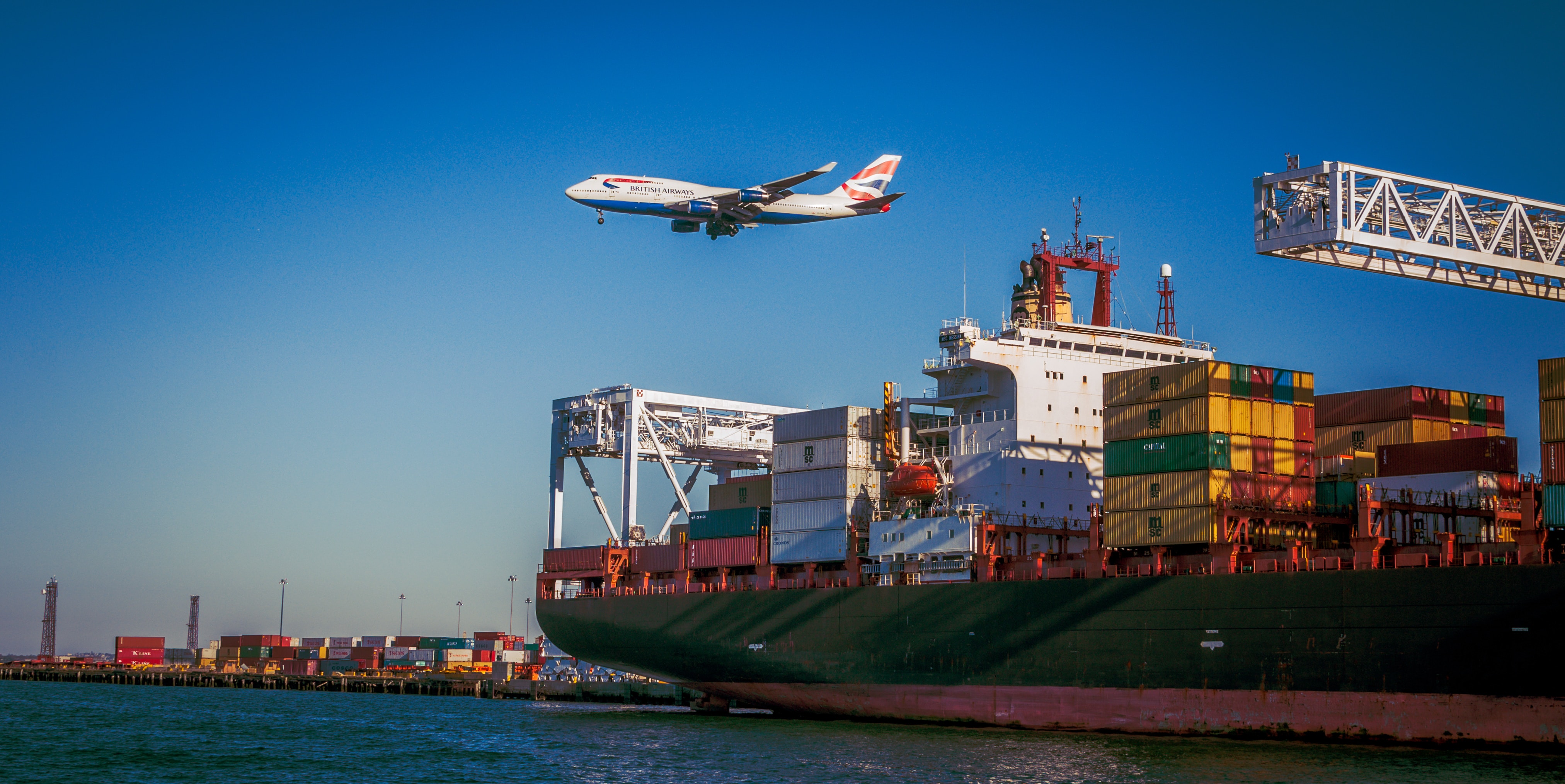 Aeroplane over container shop. Photo by VanveenJF on Unsplash.